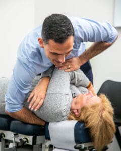 Male Geelong chiropractor performing manual chiropractic adjustment to female client