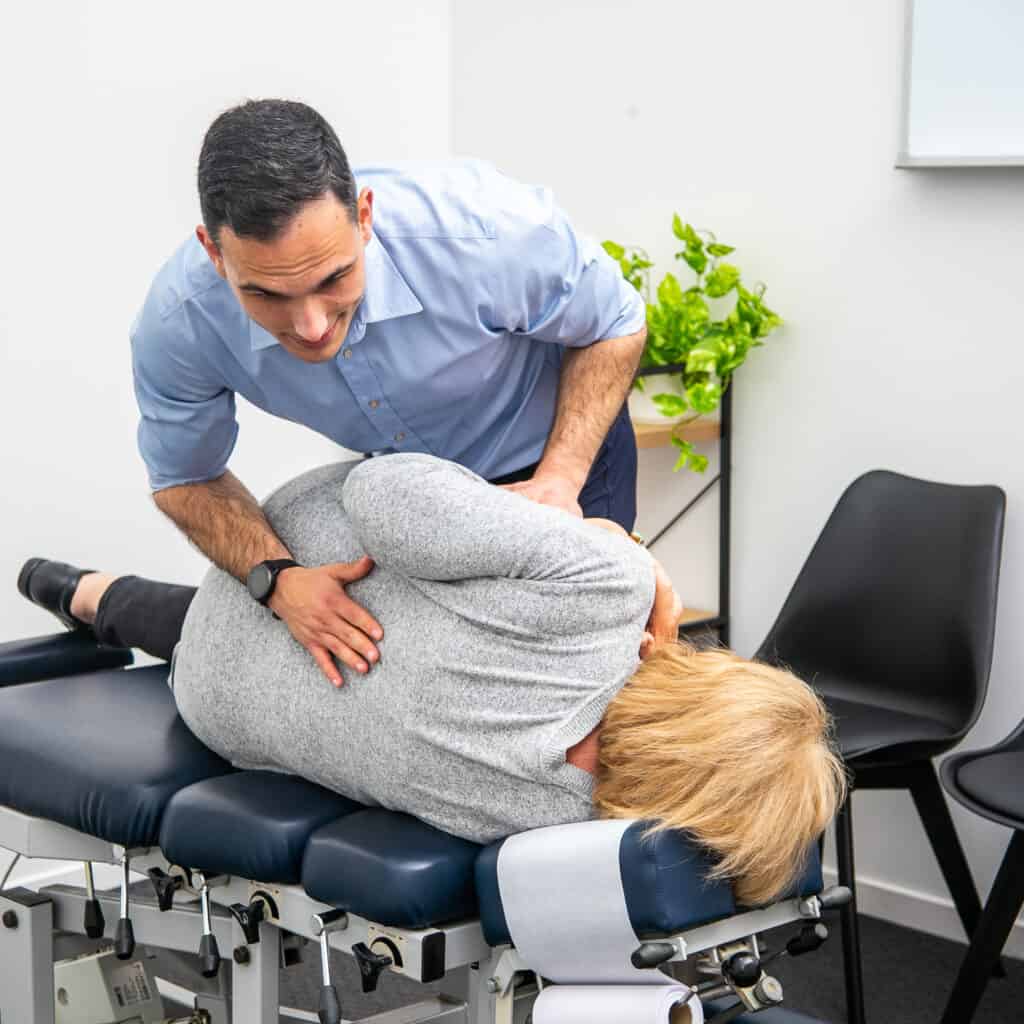Geelong chiropractor delivering manual adjustment to lower back of female client