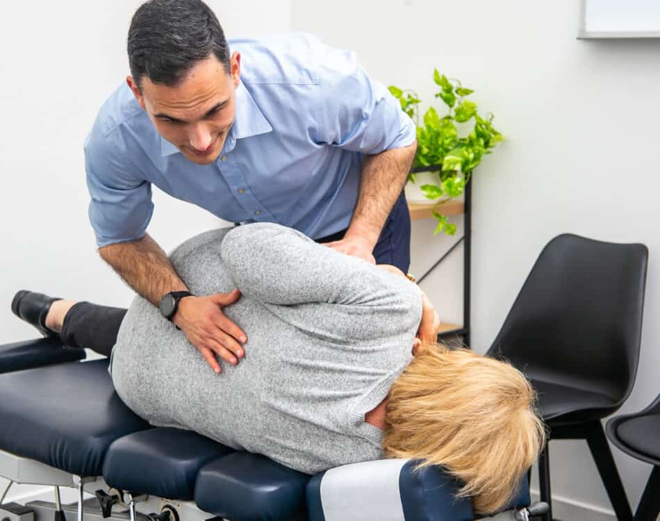 Geelong chiropractor delivering manual adjustment to lower back of female client